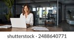 Middle age European business woman CEO using laptop application for work at table workspace in office. Smiling Latin Hispanic mature adult professional businesswoman using pc digital computer. Banner