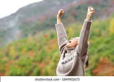 Middle Age Excited Woman Raising Arms Celebrating In The Mountain