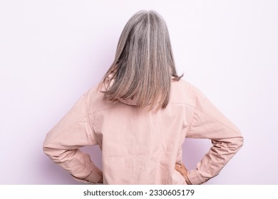 middle age gray hair woman feeling confused or full or doubts and questions, wondering, with hands on hips, rear view - Powered by Shutterstock