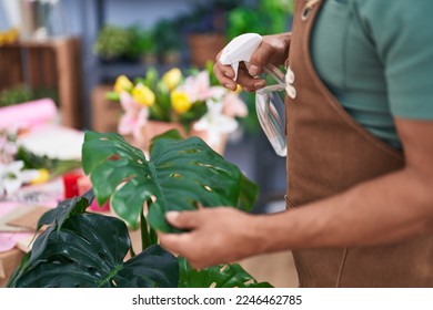 Middle age grey-haired man florist using difusser working at flower shop - Powered by Shutterstock