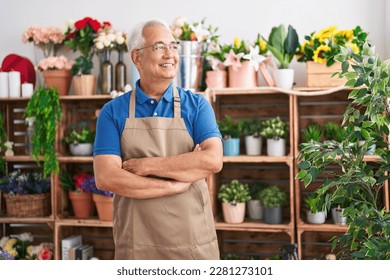 Middle age grey-haired man florist smiling confident standing with arms crossed gesture at florist - Powered by Shutterstock