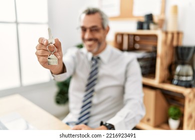 Middle Age Grey-haired Man Real State Agent Holding Key Of New Home At Office