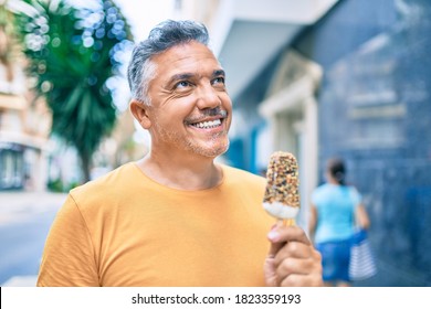 Middle Age Grey-haired Man Smiling Happy Eating Ice Cream At Street Of City.