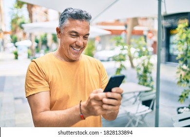 Middle age grey-haired man smiling happy using smartphone walking at street of city. - Powered by Shutterstock