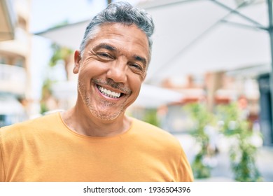 Middle age grey-haired man smiling happy walking at street of city.