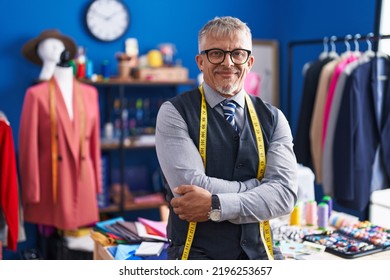 Middle age grey-haired man tailor smiling confident standing with arms crossed gesture at clothing factory - Powered by Shutterstock