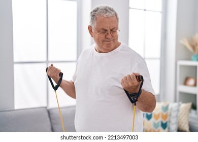 Middle Age Grey-haired Man Using Elastic Band Training At Home