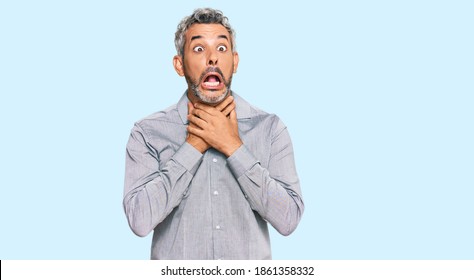 Middle age grey-haired man wearing casual clothes shouting and suffocate because painful strangle. health problem. asphyxiate and suicide concept. 