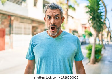 Middle Age Grey-haired Man Wearing Casual Clothes At Street Of City Scared And Amazed With Open Mouth For Surprise, Disbelief Face 