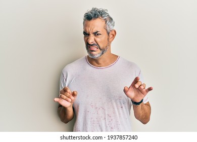 Middle age grey-haired man wearing casual clothes disgusted expression, displeased and fearful doing disgust face because aversion reaction. with hands raised 