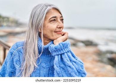 Middle age grey-haired woman smiling confident looking to the side at seaside - Powered by Shutterstock