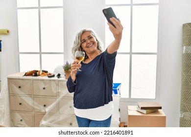 Middle Age Grey-haired Woman Toasting With Wine Making Selfie By The Smartphone At New Home.