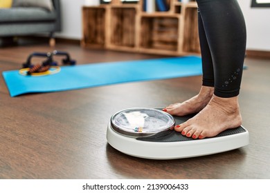 Middle age grey-haired woman using weighing machine at home