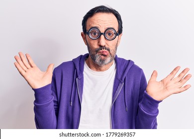 Middle Age Handsome Freaky Man Wearing Dumb Glasses Over Isolated White Background Clueless And Confused With Open Arms, No Idea And Doubtful Face.