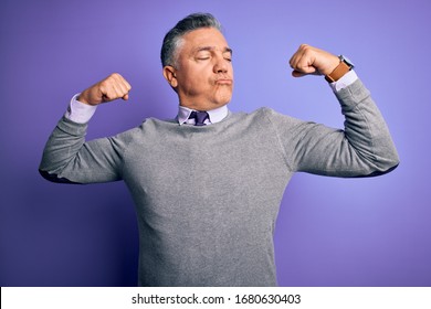 Middle Age Handsome Grey-haired Man Wearing Elegant Sweater Over Purple Background Showing Arms Muscles Smiling Proud. Fitness Concept.