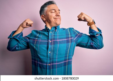 Middle Age Handsome Grey-haired Man Wearing Casual Shirt Over Isolated Pink Background Showing Arms Muscles Smiling Proud. Fitness Concept.