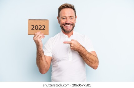 Middle Age Handsome Man Looking Excited And Surprised Pointing To The Side. 2022 Calendar Concept