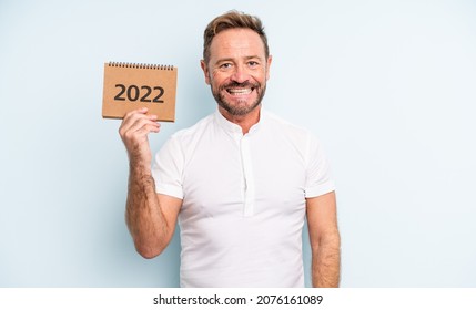 Middle Age Handsome Man Looking Happy And Pleasantly Surprised. 2022 Calendar Concept