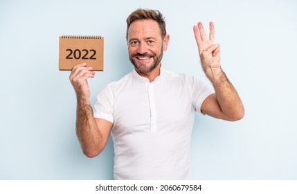 Middle Age Handsome Man Smiling And Looking Friendly, Showing Number Three. 2022 Calendar Concept