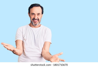 Middle age handsome man wearing casual t-shirt smiling cheerful with open arms as friendly welcome, positive and confident greetings  - Shutterstock ID 1801710670