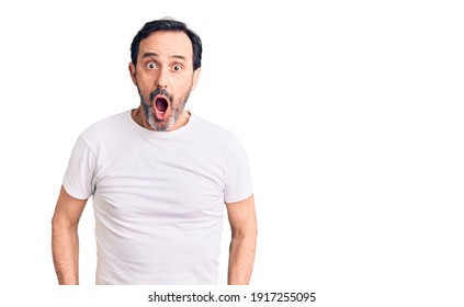 Middle age handsome man wearing casual t-shirt afraid and shocked with surprise and amazed expression, fear and excited face. 