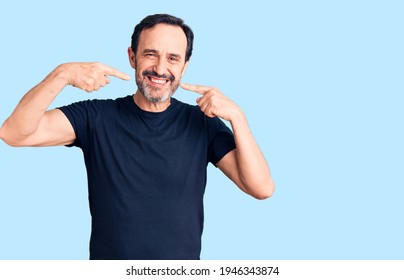 Middle age handsome man wearing casual t-shirt smiling cheerful showing and pointing with fingers teeth and mouth. dental health concept.  - Shutterstock ID 1946343874