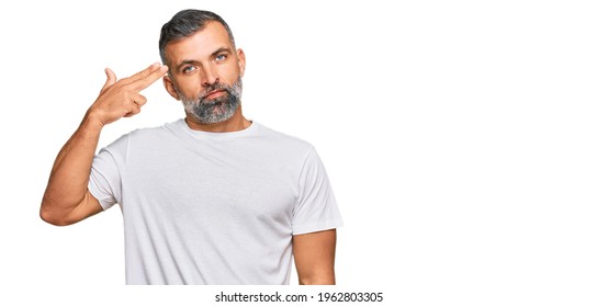 Middle Age Handsome Man Wearing Casual White Tshirt Shooting And Killing Oneself Pointing Hand And Fingers To Head Like Gun, Suicide Gesture. 