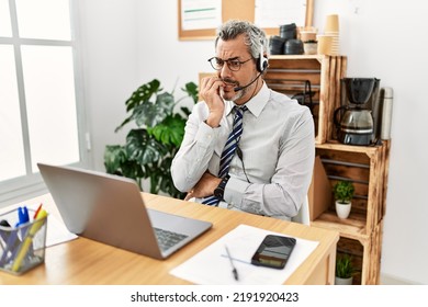 Middle Age Hispanic Business Man Working At The Office Wearing Operator Headset Looking Stressed And Nervous With Hands On Mouth Biting Nails. Anxiety Problem. 