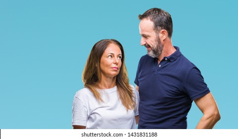 Middle Age Hispanic Casual Couple Over Isolated Background With Serious Expression On Face. Simple And Natural Looking At The Camera.