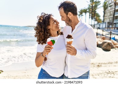 Middle age hispanic couple hugging and eating ice cream at the beach. - Powered by Shutterstock