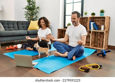 Middle Age Hispanic Couple Smiling Happy Doing Online Yoga Class At Home.