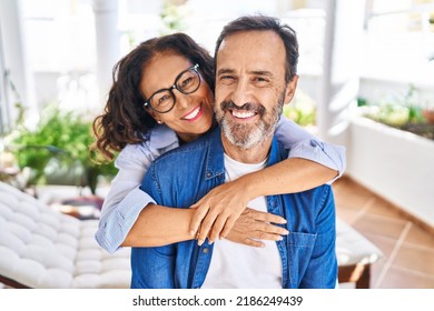 Middle age hispanic couple smiling confident hugging each other sitting on hammock at terrace - Shutterstock ID 2186249439