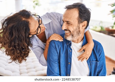 Middle age hispanic couple smiling confident hugging each other sitting on hammock at terrace - Shutterstock ID 2248538707