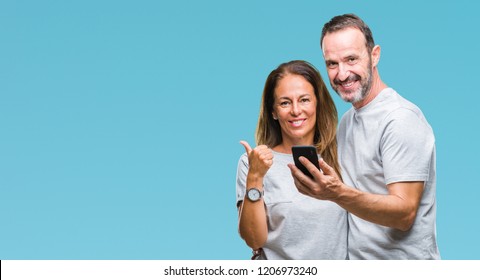 Middle Age Hispanic Couple Texting Message On Smartphone Ver Isolated Background Happy With Big Smile Doing Ok Sign, Thumb Up With Fingers, Excellent Sign