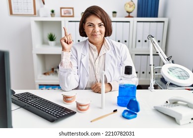 Middle Age Hispanic Dentist Woman Working At Medical Clinic Smiling Happy Pointing With Hand And Finger To The Side 