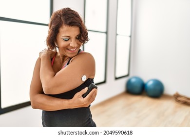 Middle age hispanic diabetic woman control glucose after training at sport center. - Powered by Shutterstock