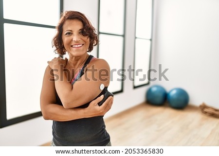 Middle age hispanic diabetic woman control glucose after training at sport center.