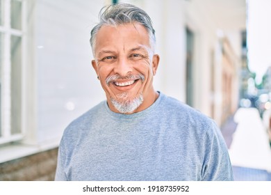 Middle age hispanic grey-haired man smiling happy standing at the city. - Powered by Shutterstock