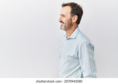 Middle age hispanic man with beard standing over isolated background looking to side, relax profile pose with natural face and confident smile.  - Shutterstock ID 2070943580