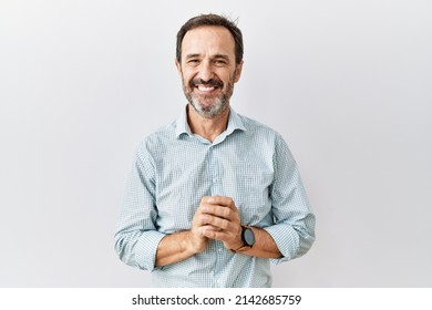 Middle age hispanic man with beard standing over isolated background hands together and fingers crossed smiling relaxed and cheerful. success and optimistic  - Shutterstock ID 2142685759