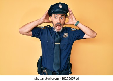 Middle Age Hispanic Man Wearing Police Uniform Crazy And Scared With Hands On Head, Afraid And Surprised Of Shock With Open Mouth 