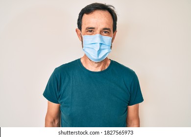 Middle Age Hispanic Man Wearing Medical Mask Looking Positive And Happy Standing And Smiling With A Confident Smile Showing Teeth 