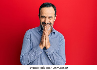 Middle Age Hispanic Man Wearing Casual Clothes Praying With Hands Together Asking For Forgiveness Smiling Confident. 