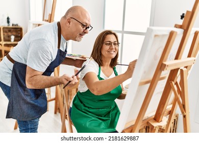 Middle Age Hispanic Painter Couple Smiling Happy Painting At Art Studio.