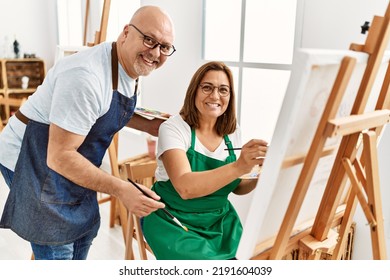 Middle Age Hispanic Painter Couple Smiling Happy Painting At Art Studio.