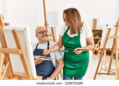 Middle Age Hispanic Painter Couple Smiling Happy Painting At Art Studio.