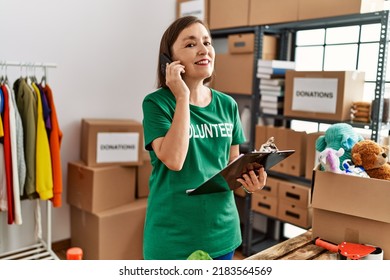 Middle age hispanic woman checking donations speaking on the phone at donations stand - Shutterstock ID 2183564569