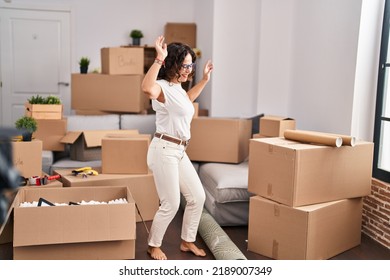 Middle Age Hispanic Woman Dancing At New Home