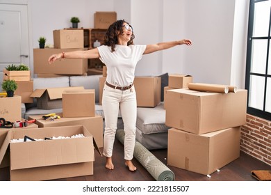 Middle Age Hispanic Woman Dancing At New Home