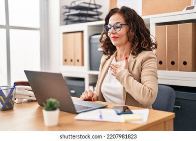 Middle Age Hispanic Woman Doing Video Call Using Sign Language At The Office